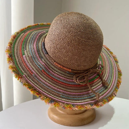 Top view of brown raffia sun hat with colorful wide brim and frayed edge detail.