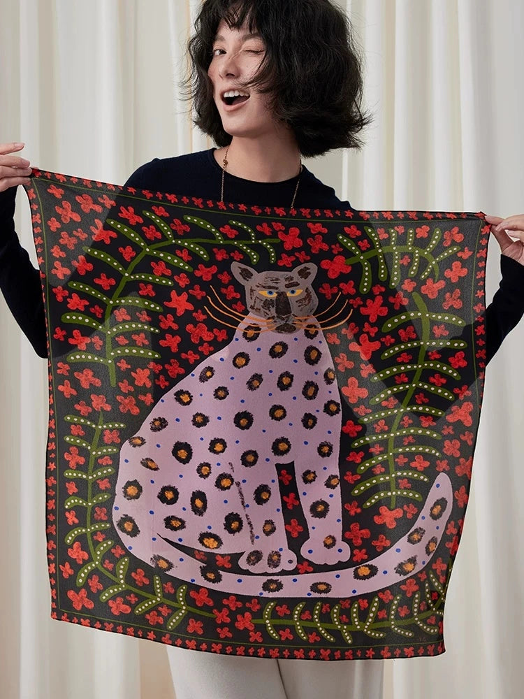 Woman holding a crimson red and black leopard floral mulberry silk square scarf