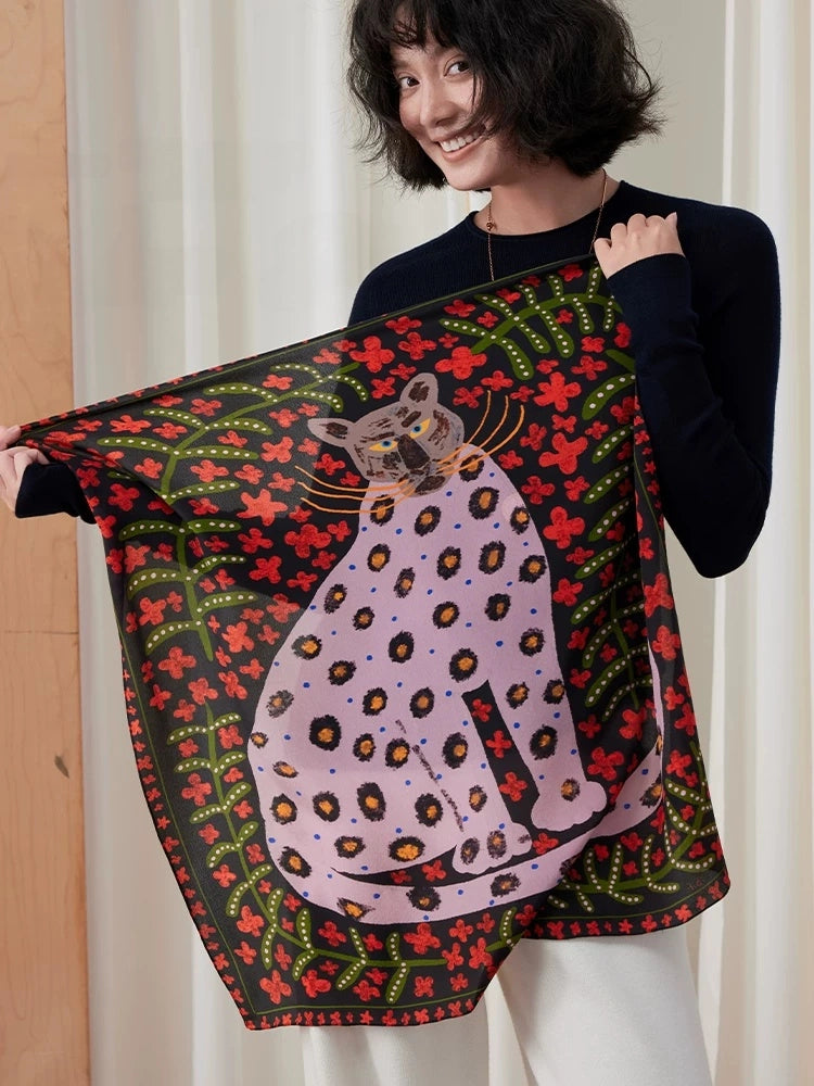 Model displaying a crimson red silk square scarf with a spotted leopard and botanical print