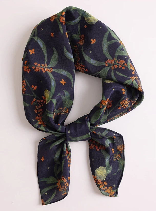 Close-up of dark blue osmanthus silk scarf, showcasing the delicate floral print and luxurious texture.