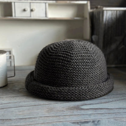 Front view of a dark gray wool blend dome beanie with a thick rolled edge and structured crown