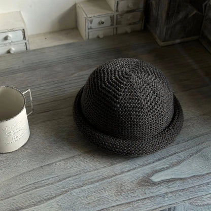 Dark gray wool blend knit hat with a rounded crown and rolled brim shown from an elevated angle