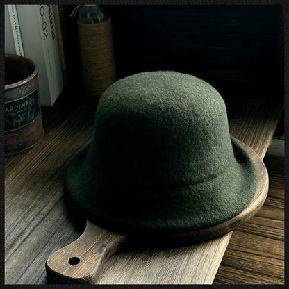 Rear view of a dark green wool felt cloche hat showing the sculpted dome crown and rolled brim
