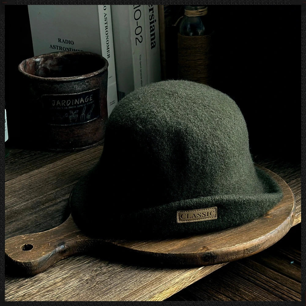 Front view of a dark green women's wool cloche hat with a rolled brim and small logo patch