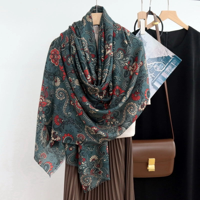 Oversized dark green floral wool scarf draped as a shawl over a pleated brown skirt