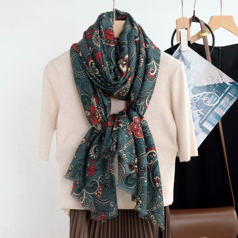Dark green paisley floral wool scarf wrapped and softly knotted over a cream top