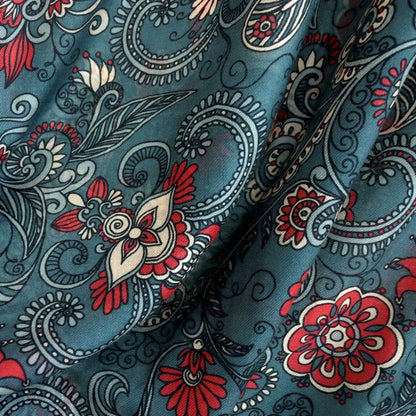 Close-up of dark green wool scarf fabric with red flowers and intricate blue paisley motifs