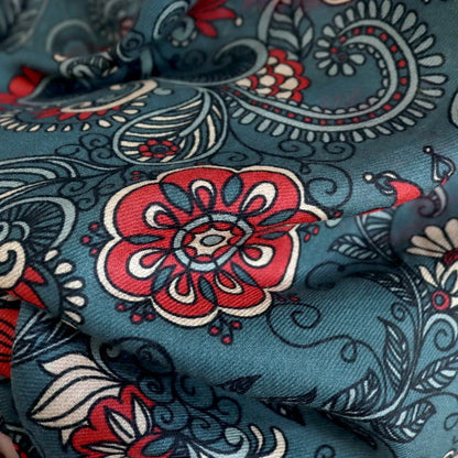 Detailed view of red floral medallions and paisley print on the dark green wool scarf