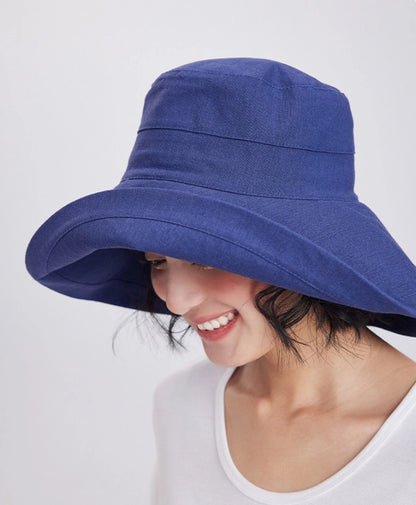 Side view of a deep blue linen blend sun hat with a softly curved wide brim
