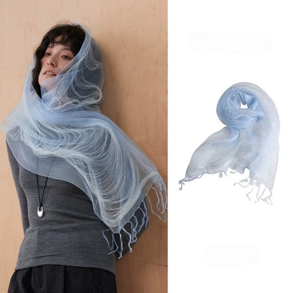 Woman wearing a distant mountain blue sheer mulberry silk fringe scarf over a gray top