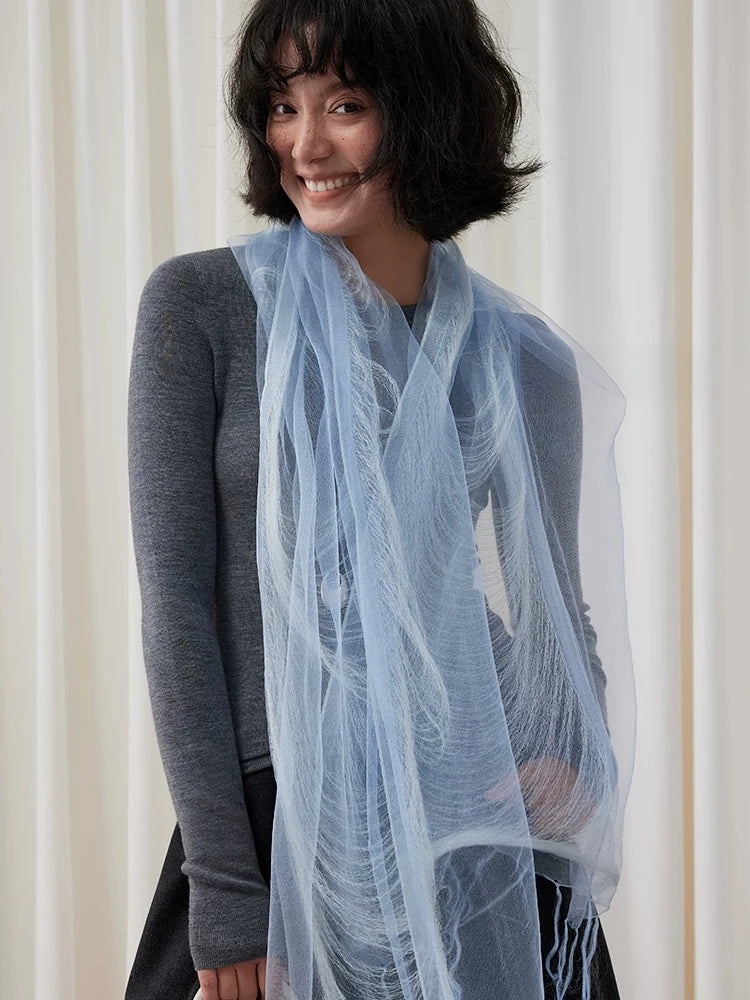 Lightweight blue mulberry silk scarf draped loosely around the neck with long fringed ends