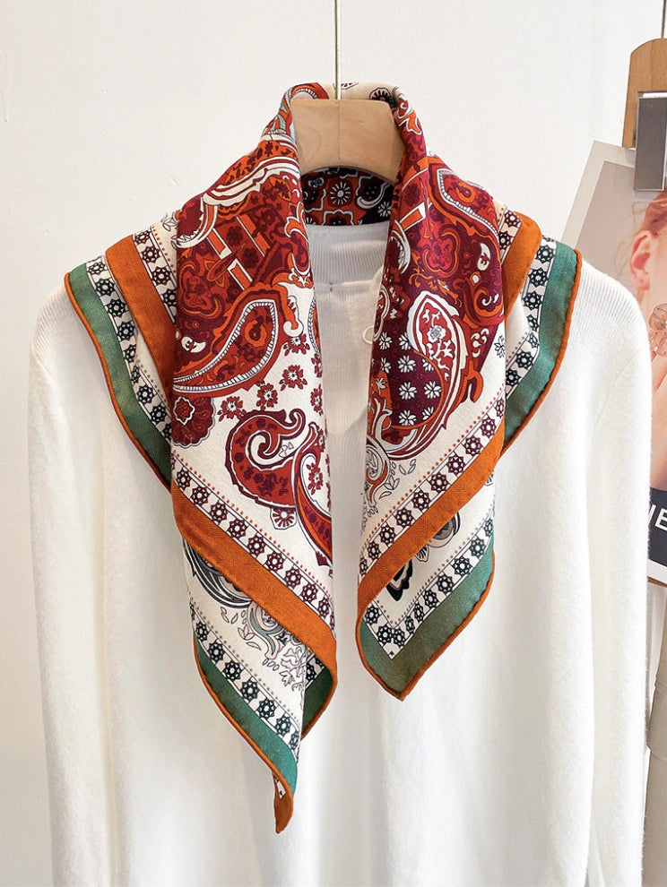 Double-sided silk wool square scarf with vintage paisley print in rust red and green, styled on neck