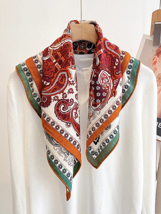 Double-sided silk wool square scarf with vintage paisley print in rust red and green, styled on neck