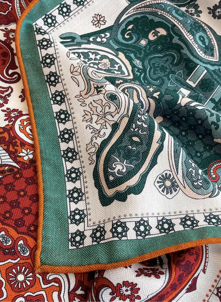Close-up of silk wool square scarf corner with green border and intricate paisley detailing