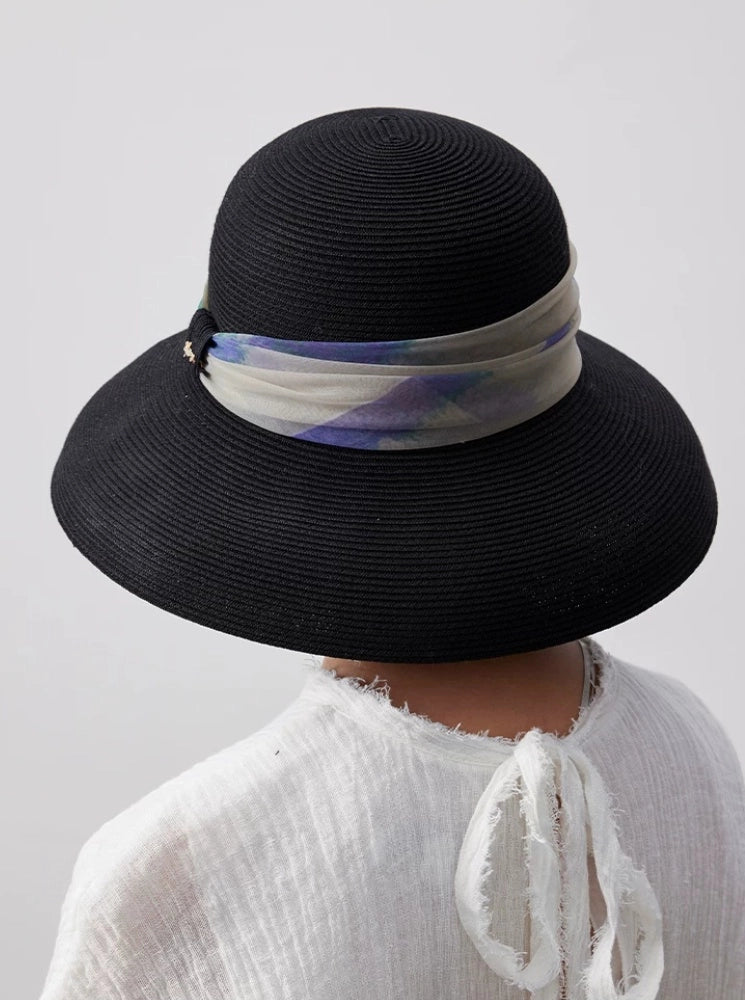 Rear view of elegant black dome crown sun hat with scarf ribbon and wide brim.