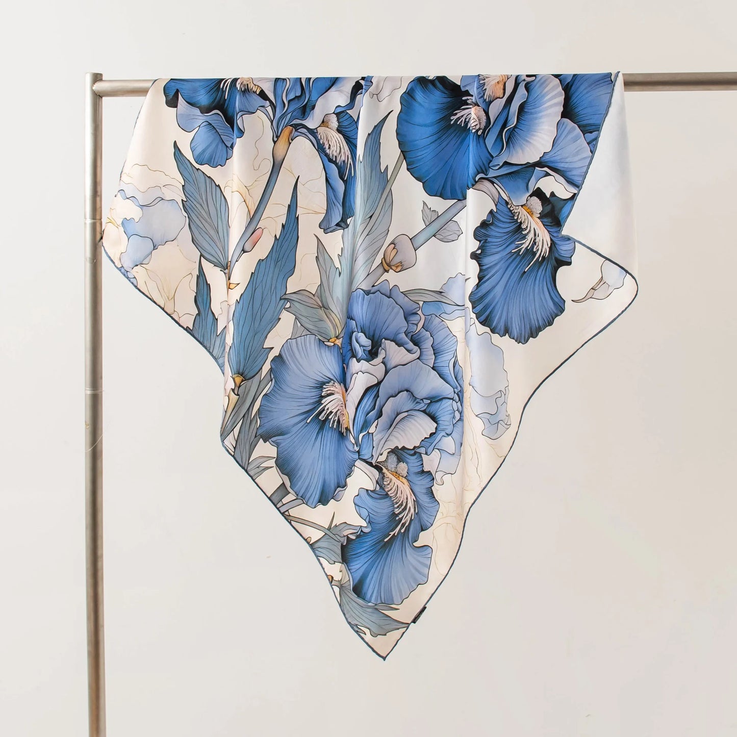 Lightweight blue floral silk square scarf displayed in elegant triangle styling