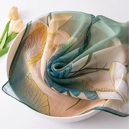 Close-up of sheer mulberry silk scarf with lotus floral print and soft artistic details