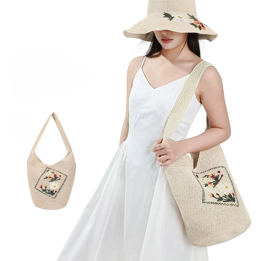 Woman carrying an ivory floral embroidered woven straw shoulder bag with matching wide brim sun hat for summer vacation outfits