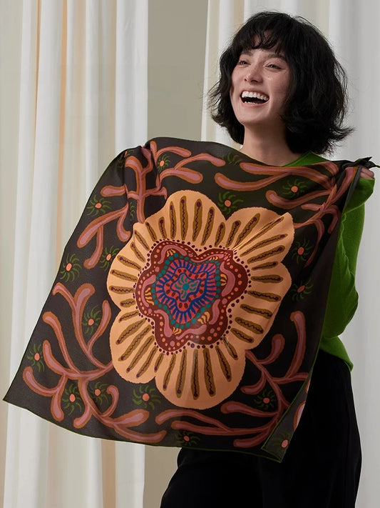 Woman displaying an espresso brown mulberry silk square scarf with an oversized vintage floral medallion