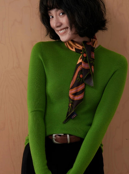 Woman styling an espresso brown mulberry silk neck scarf with long pointed ends and a green sweater