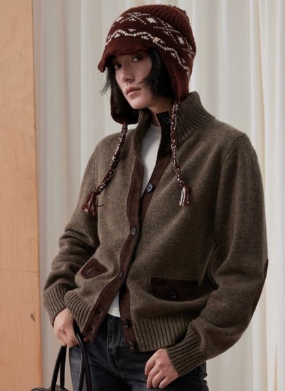 Model wearing a coffee brown Fair Isle earflap beanie with a brown cardigan and dark jeans.