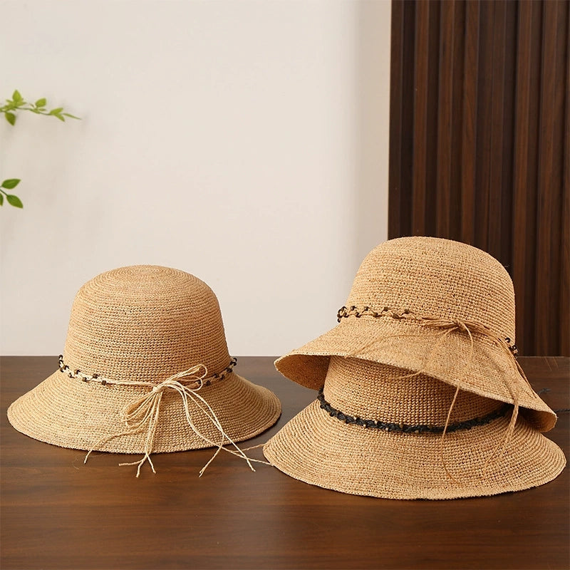 Natural raffia sun hats with bow details and wide brims, shown together for summer beach and travel styling.