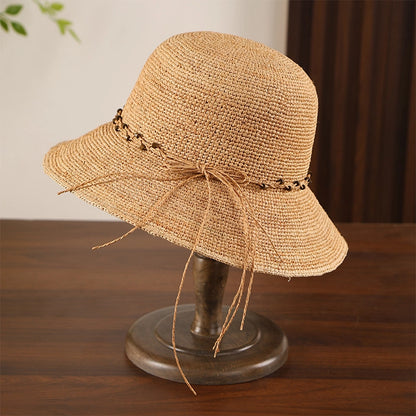 Khaki bow raffia sun hat with curved wide brim and natural straw look for French countryside summer style.