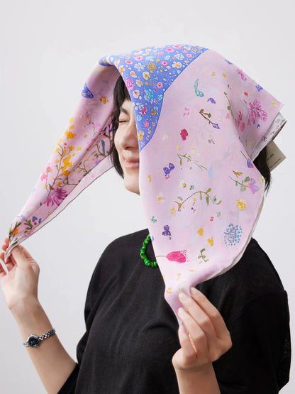Dolphin print silk square scarf styled as a soft silk head wrap in pink floral design.