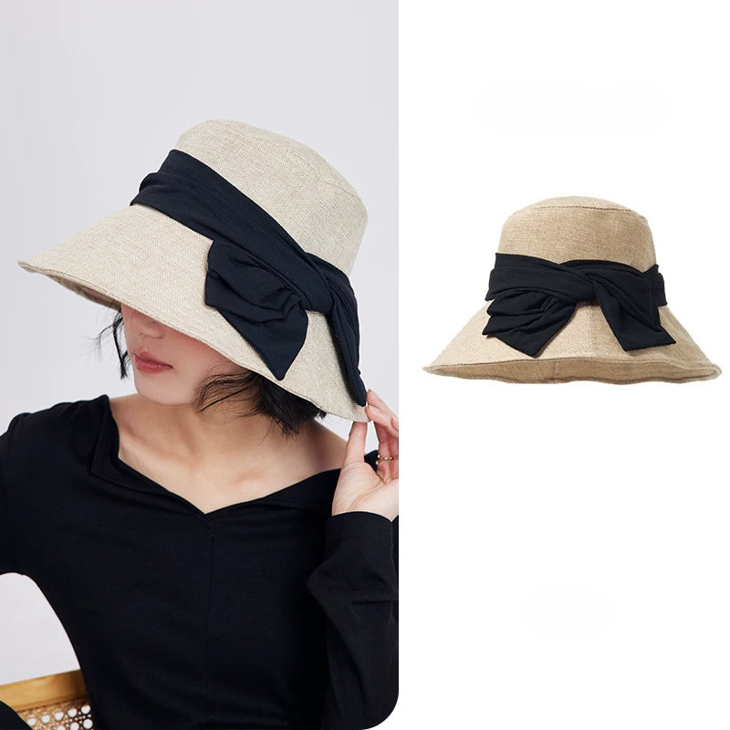 Beige foldable wide brim bow sun hat for women with breathable woven texture and elegant black ribbon detail.