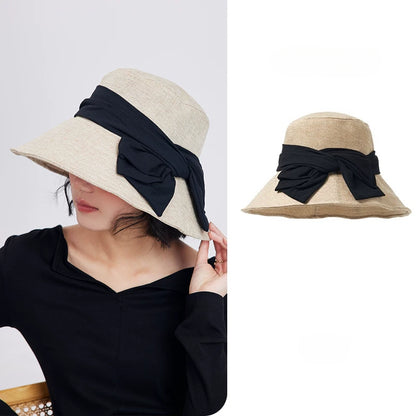 Beige foldable wide brim bow sun hat for women with breathable woven texture and elegant black ribbon detail.