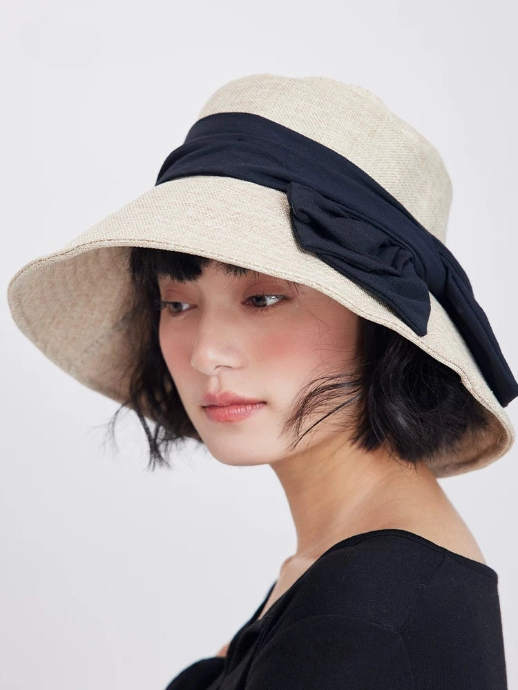 Side view of beige bowknot summer hat with wide brim, soft woven texture, and elegant feminine styling.