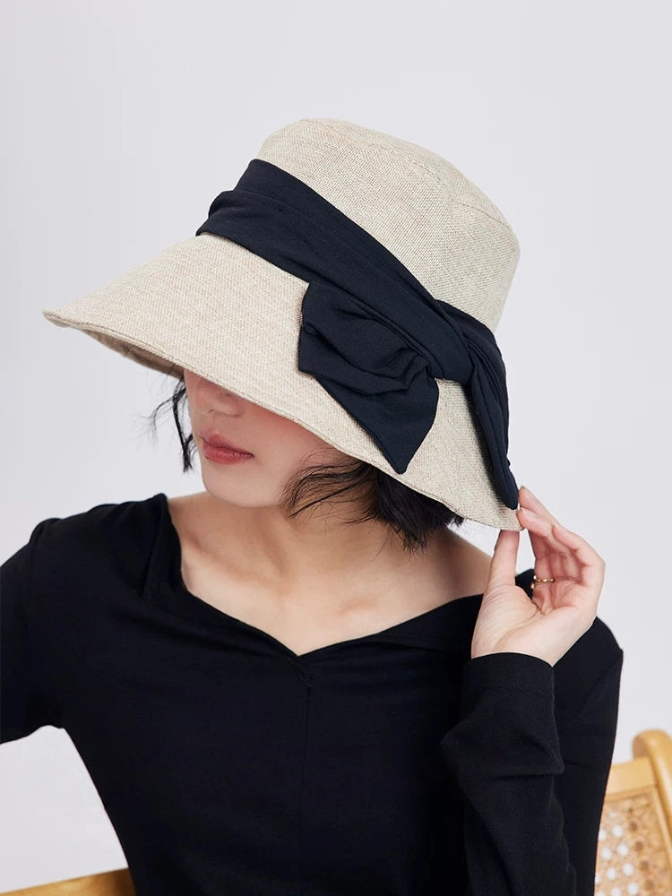 Beige bucket hat with bow and wide brim, styled for daily city wear, beach trips, and summer outdoor occasions.