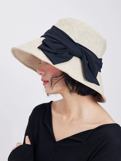 Woman styling a beige chic bow ribbon hat with wide brim for vacation, café, and warm-weather outfits.