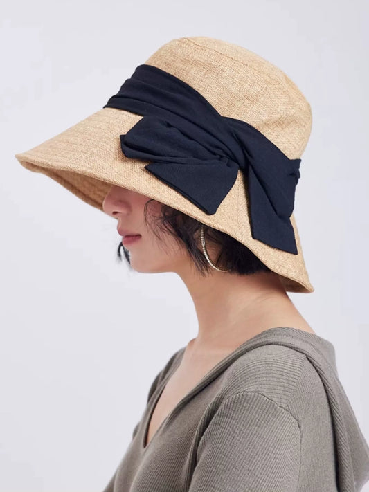  Side view of natural flax bowknot summer hat with wide brim and breathable woven texture for outdoor wear.