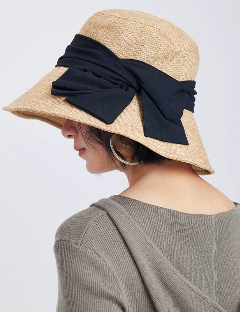 Back side view of natural flax bucket hat with bow, foldable brim, and feminine summer styling.