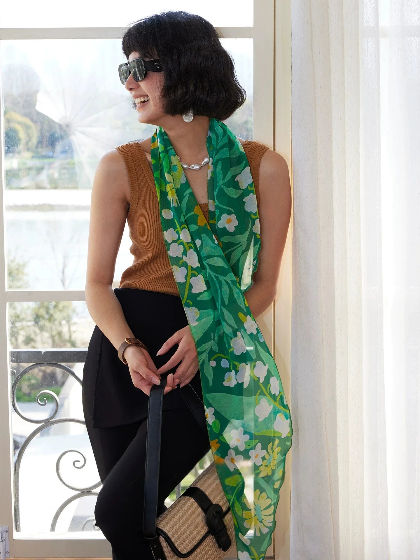 Forest green long silk scarf styled with brown top and black skirt for a chic vacation outfit
