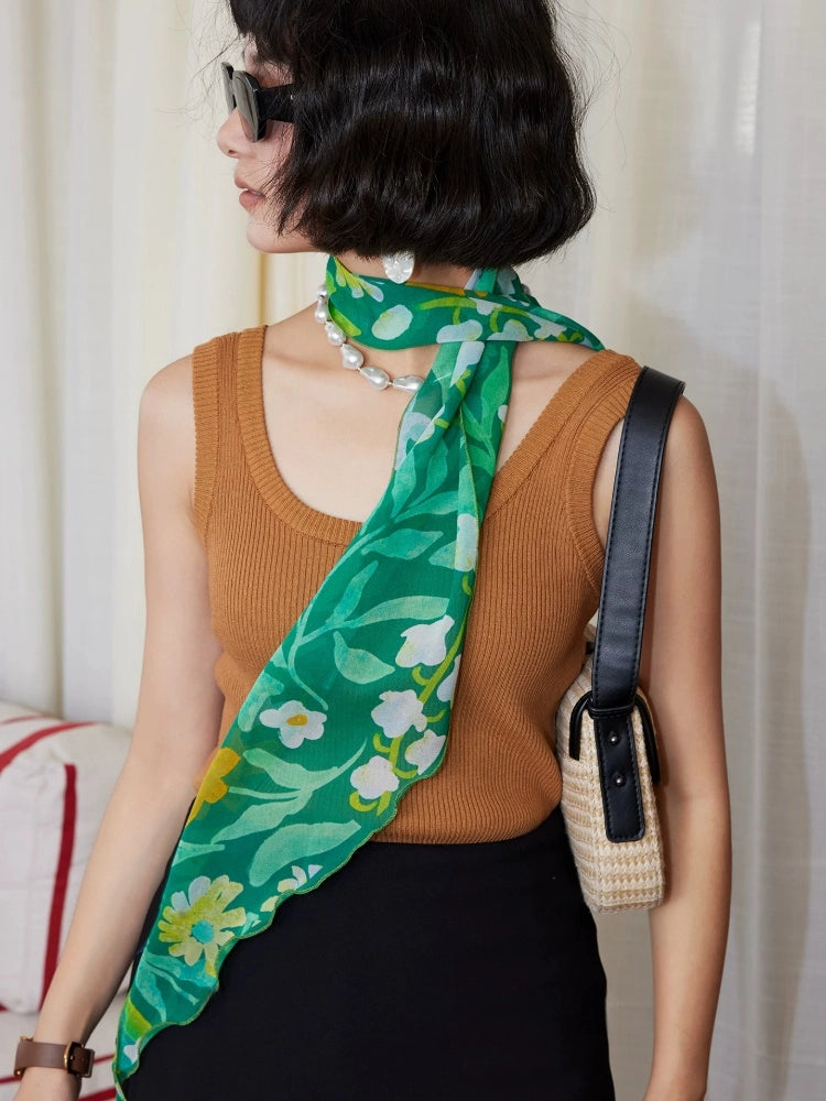 Forest green botanical print silk scarf worn as a long neck scarf with handbag styling