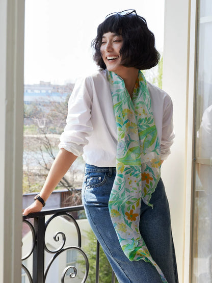 Model wearing a fresh green botanical skinny silk scarf with white shirt and jeans for summer styling