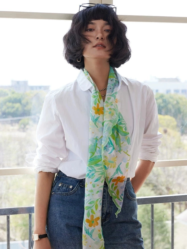 Fresh green long silk scarf worn with white blouse and jeans as a breathable summer accessory