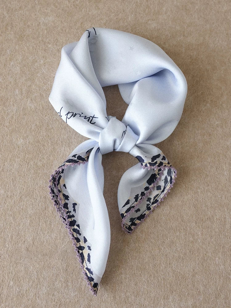 Glacier blue mulberry silk square scarf with leopard trim styled in a loose knot