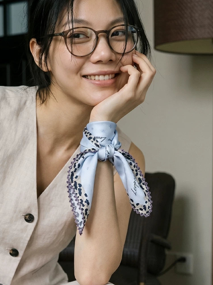 Glacier blue leopard-trim silk scarf styled as an elegant wrist wrap