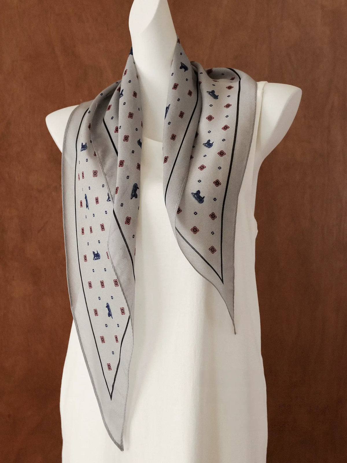 Gray ditsy floral silk wool diamond scarf draped over a white mannequin