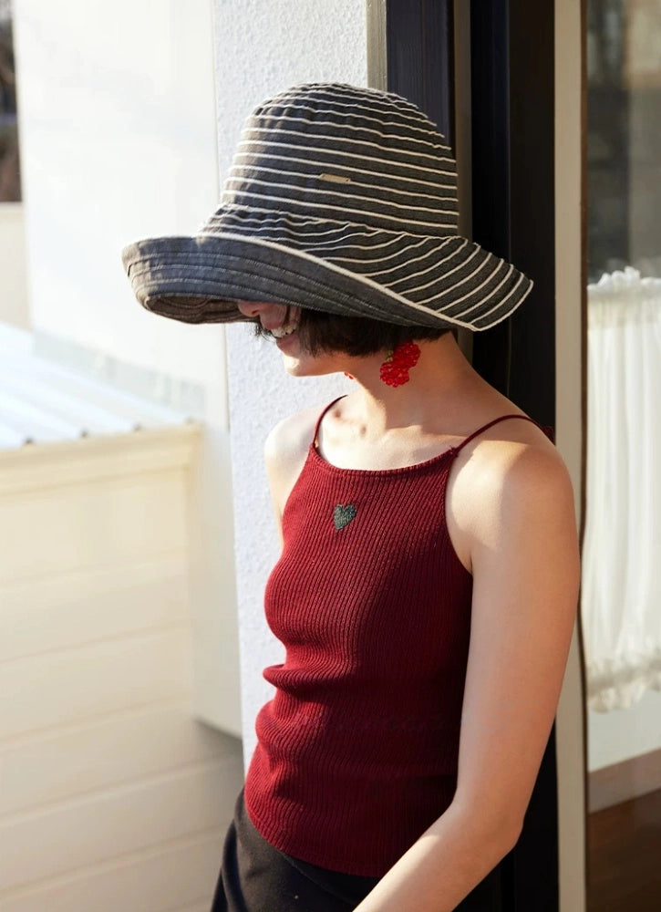 Gray and white striped beach sun hat with a flexible wide brim styled for warm-weather travel.