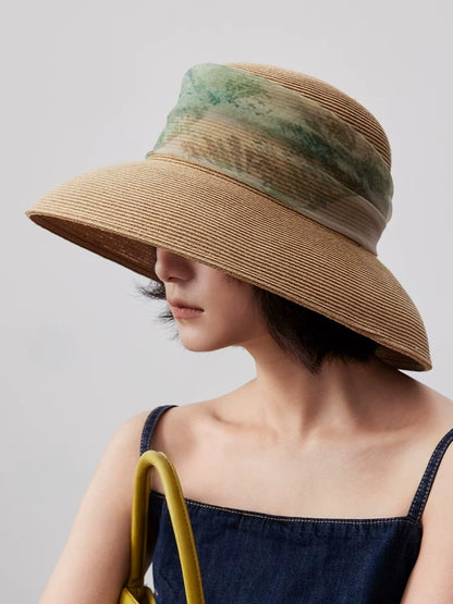 Side view of herbal beige scarf ribbon sun hat styled with navy sleeveless dress.