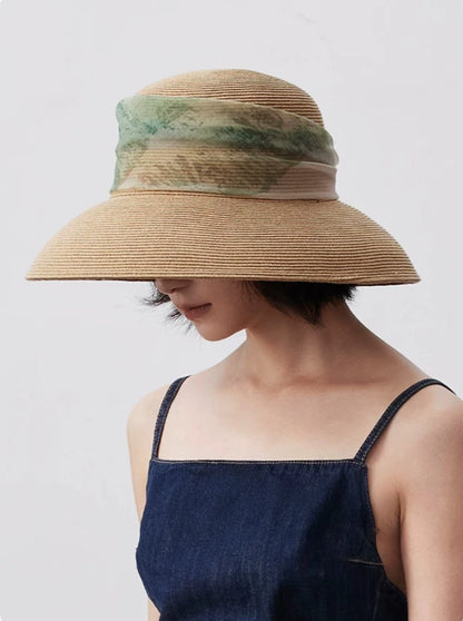 Woman wearing herbal beige lampshade sun hat with artistic scarf ribbon detail.