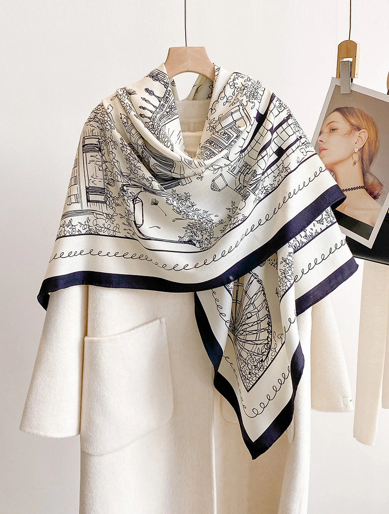 Large ivory cityscape silk wool scarf draped over the shoulders of a white outfit