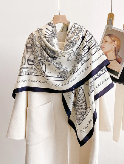 Large ivory cityscape silk wool scarf draped over the shoulders of a white outfit