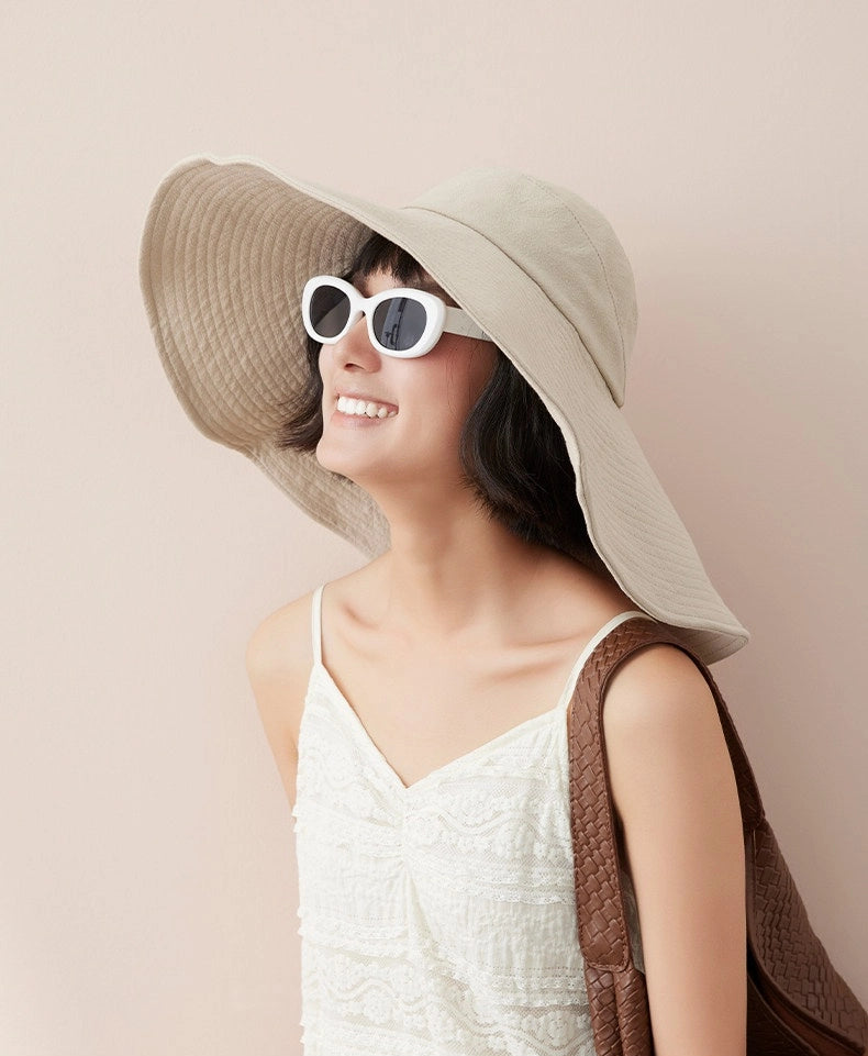 Side view of ivory oversized cotton sun hat with floppy wide brim for vacation styling