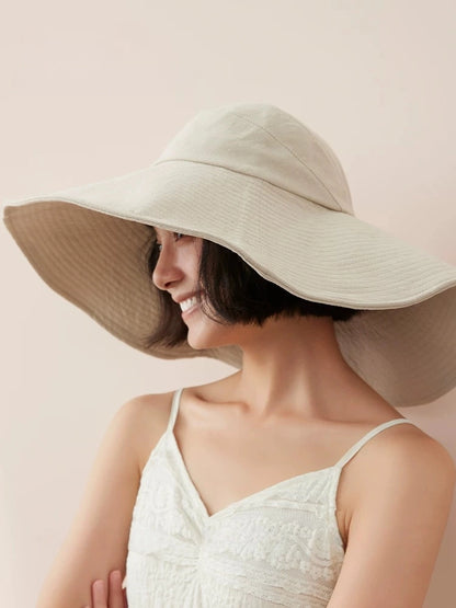 Woman wearing ivory wide brim summer hat with breathable cotton fabric and relaxed resort look