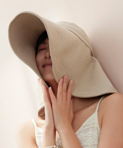 Close-up of ivory cotton oversized sun hat with soft floppy brim and wind cord